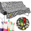 Black and white patterned towel with colorful markers and a round product with fruit design.